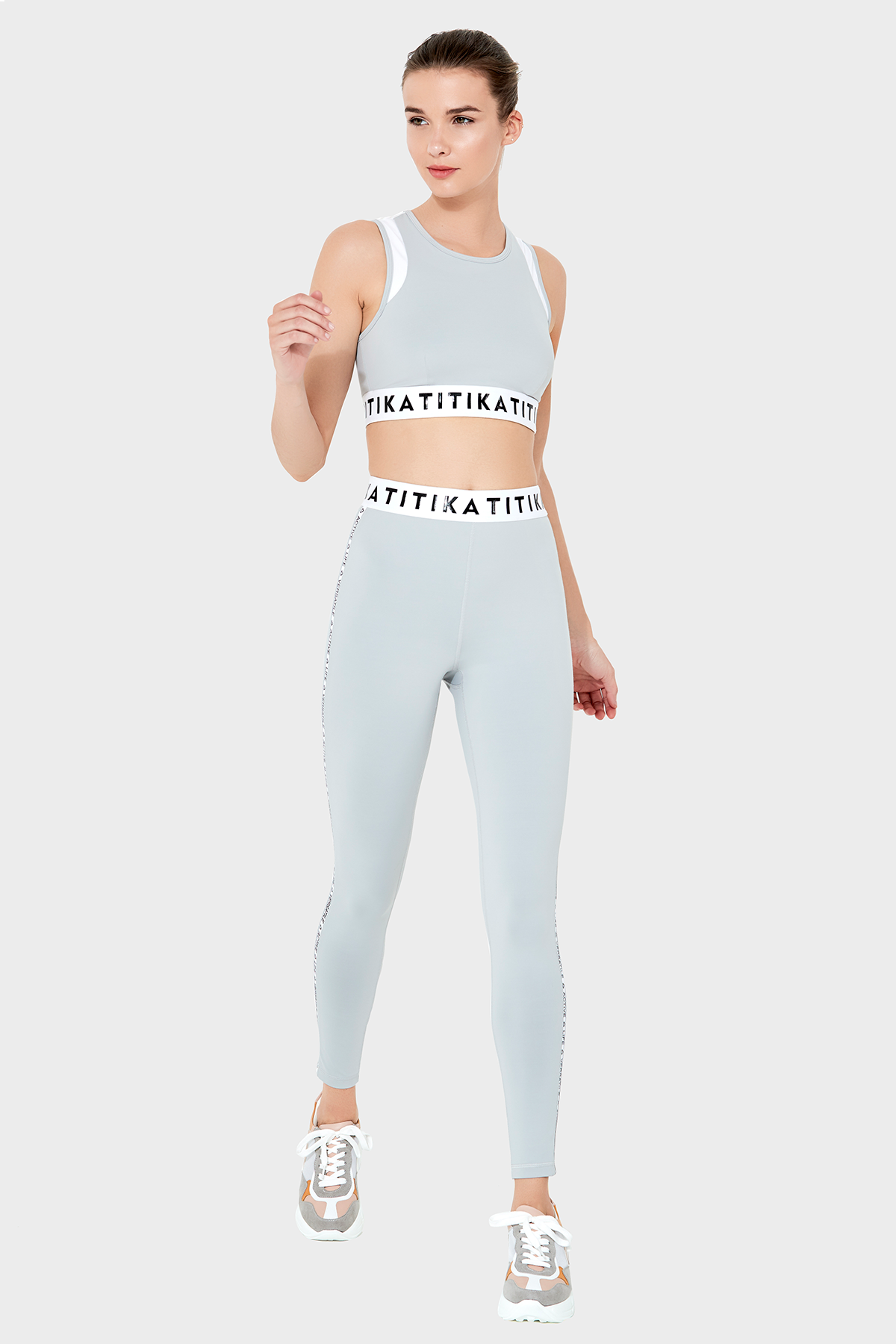 Front view of a woman wearing Titika Active Wear’s sleek, high-waisted black leggings with mesh panels, designed for comfort and breathability during workouts.