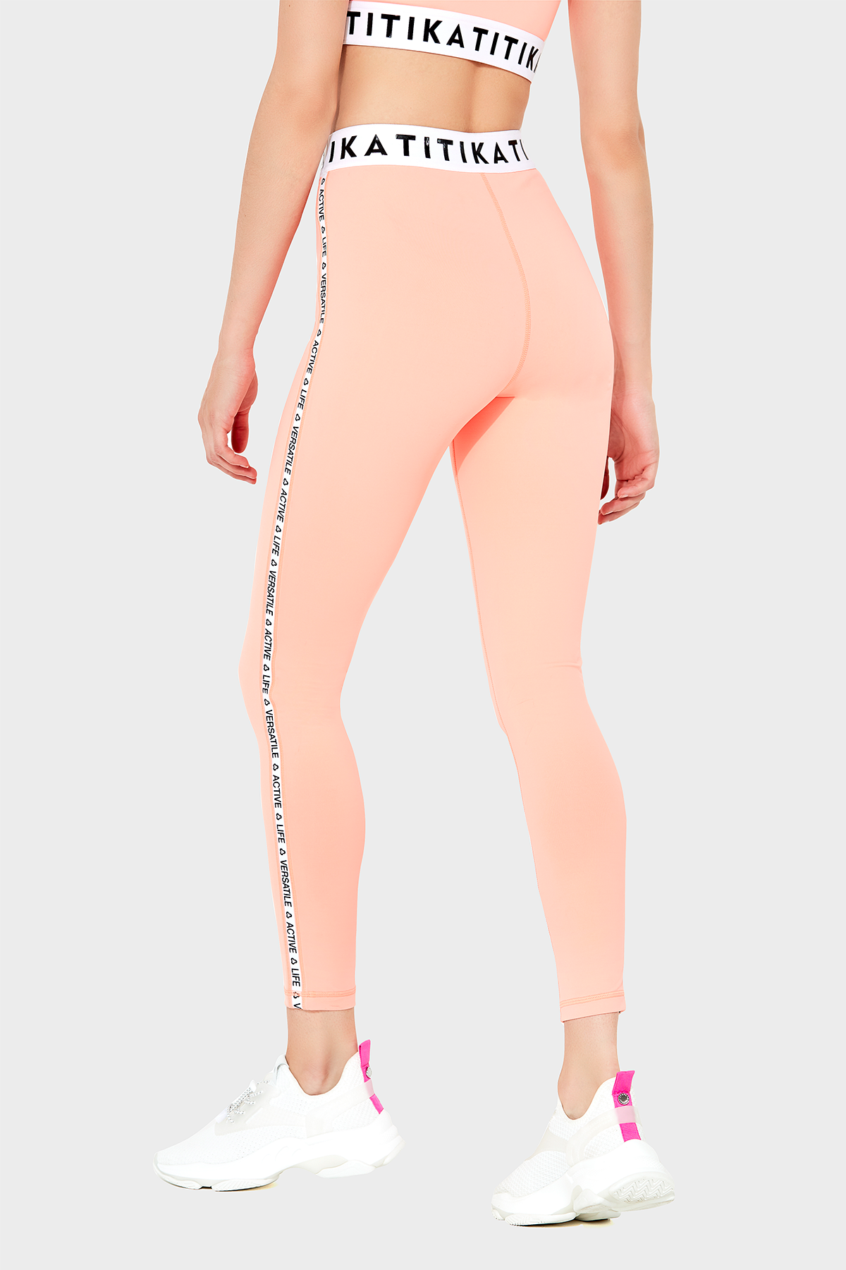 Front view of a woman wearing Titika Active Wear’s sleek, high-waisted black leggings with mesh panels, designed for comfort and breathability during workouts.