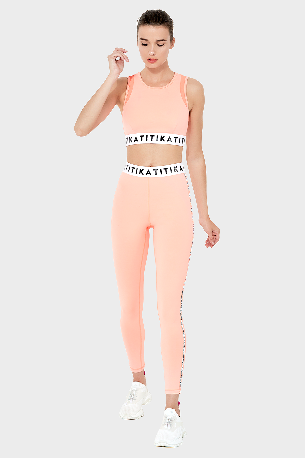 Front view of a woman wearing Titika Active Wear’s sleek, high-waisted black leggings with mesh panels, designed for comfort and breathability during workouts.