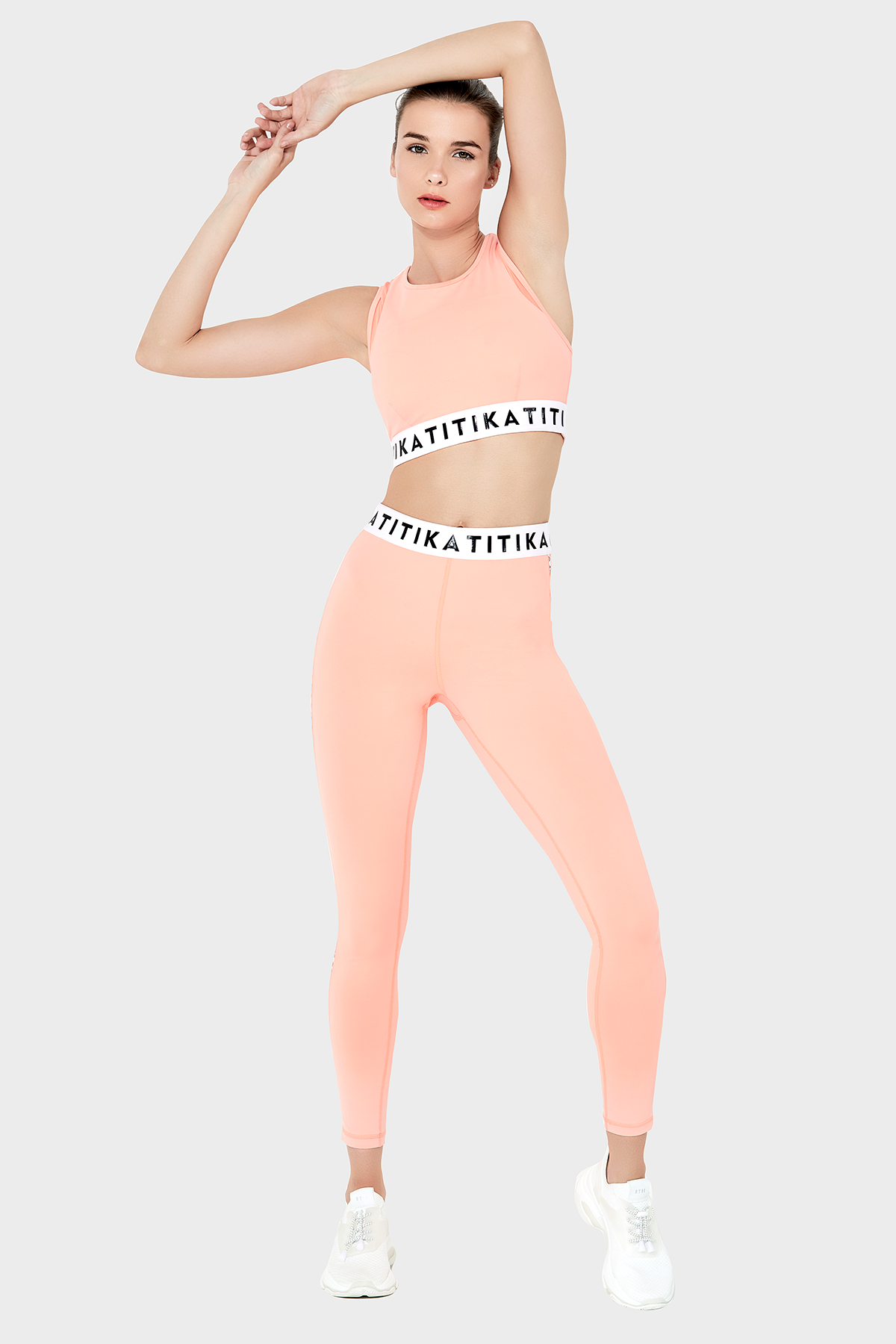 Front view of a woman wearing Titika Active Wear’s sleek, high-waisted black leggings with mesh panels, designed for comfort and breathability during workouts.